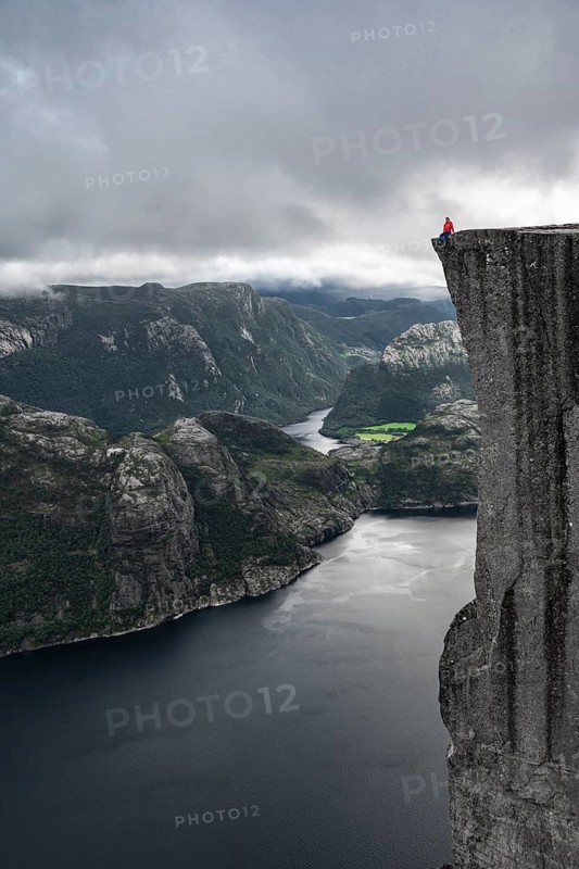 Person sitting on steep cliff