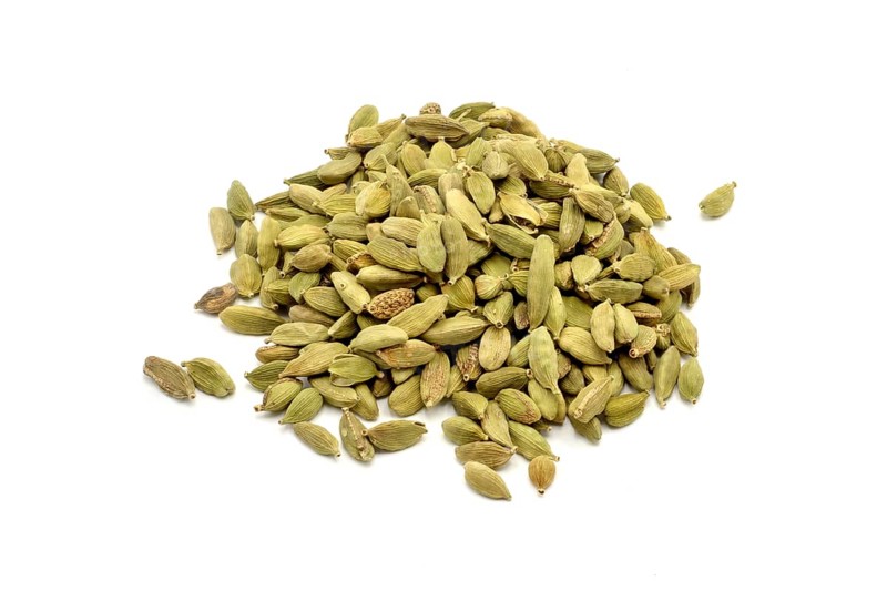 A pile of cardamom pods against a white background