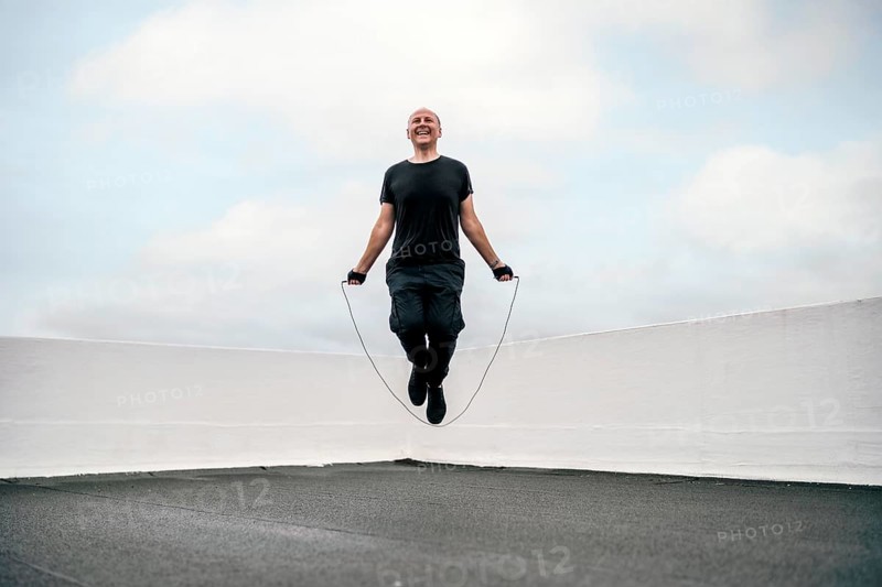 A man exercising on the rooftop using a jumping rope during lockdown