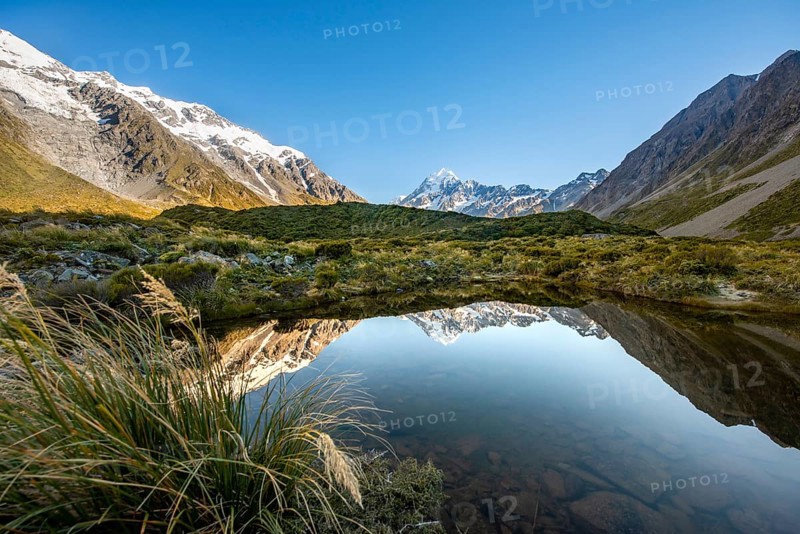 Reflection in small mountain lake at sunrise