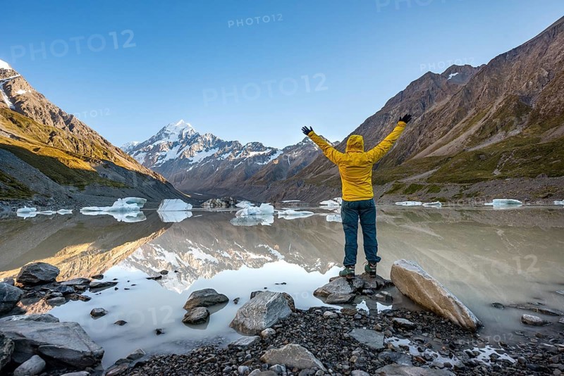 Hiker at the lake stretching her arms in the air