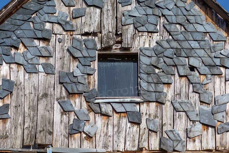 Broken slate facade of an old farmhouse