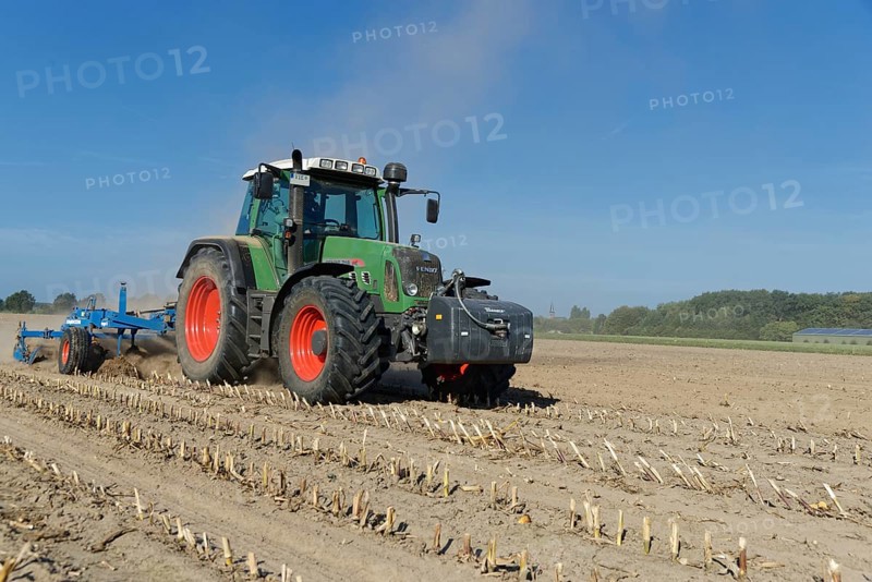 Farmer cultivating harvested maize field