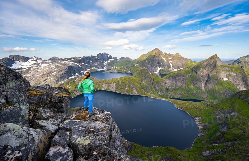 Young woman looking over mountain landscape with lake Tennesvatnet and Krokvatnet