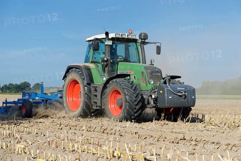 Farmer cultivating harvested maize field