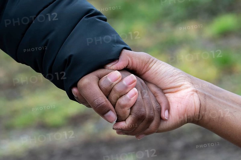 A Somali woman who fled to Germany holds the hand of her eight-year-old son