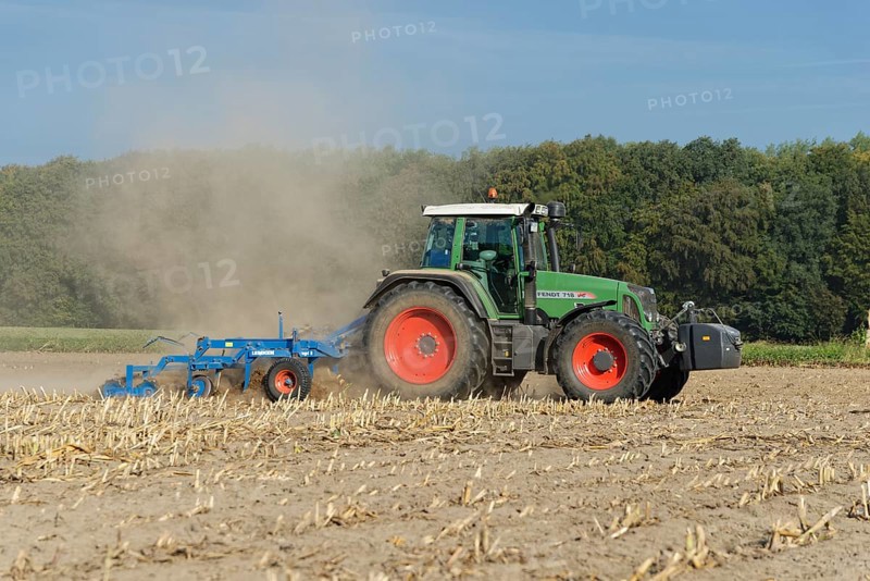 Farmer cultivating harvested maize field