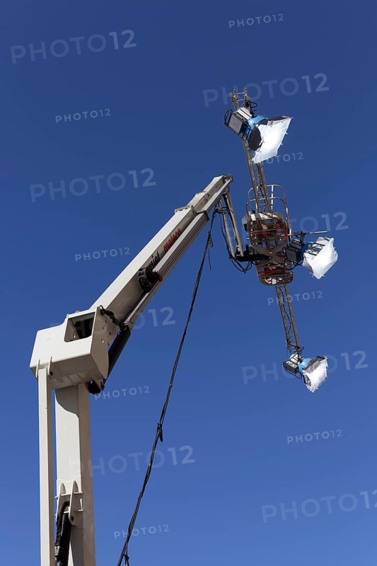Three spotlights in front of a blue sky
