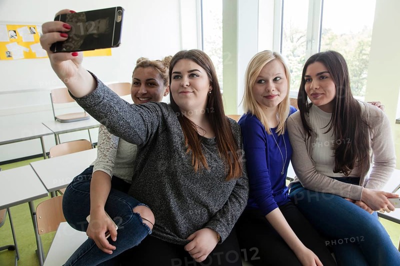 Vocational school students with their smartphones during break at the Elly-Heuss-Knapp-Schule