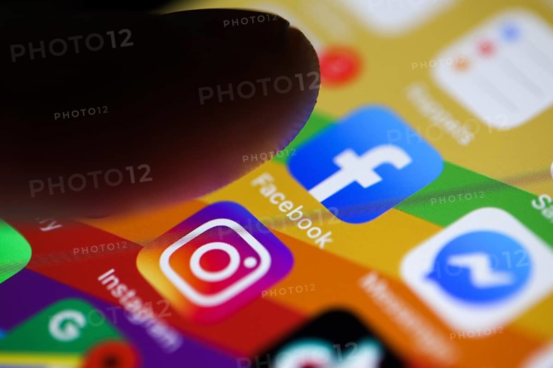 Finger about to press on the Facebook app icon on a smartphone