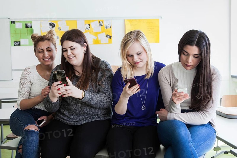 Vocational school students with their smartphones during break at the Elly-Heuss-Knapp-Schule