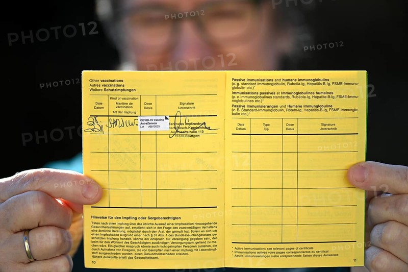 Woman proudly showing her vaccination certificate after being vaccinated with AstraZeneca against Covid-19