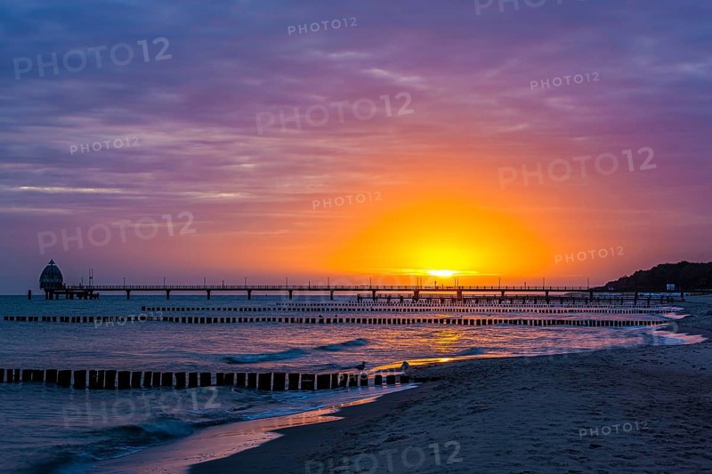 Groyne and diving gondola with pier at the beach of Zingst at sunrise