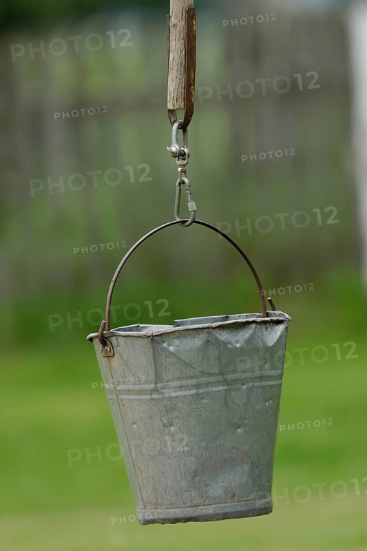 Dented metal bucket on wellstick