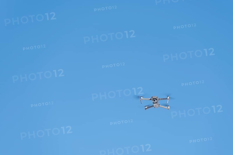 Drone flies in front of blue sky
