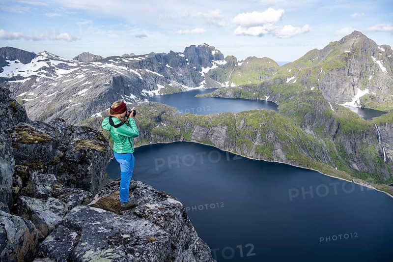 Young woman looking over mountain landscape with lake Tennesvatnet