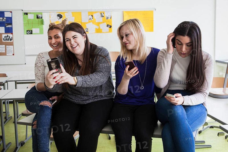 Vocational school students with their smartphones during break at the Elly-Heuss-Knapp-Schule