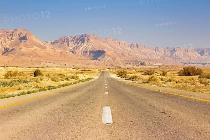 Endless road driving empty desert landscape boundless loneliness infinite distance in Israel