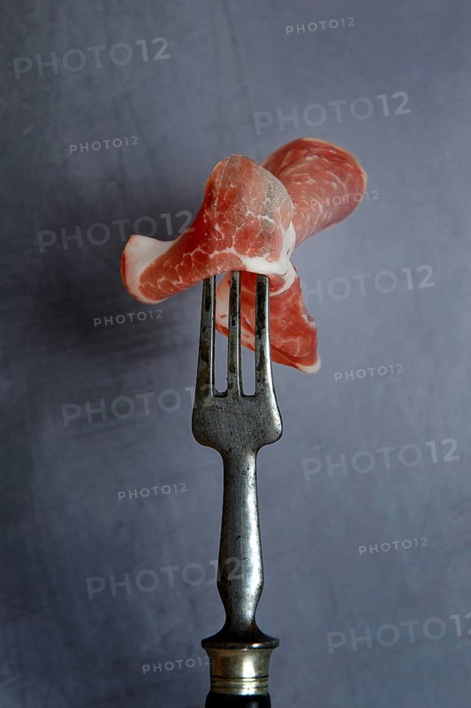 A slice of coppa on fork