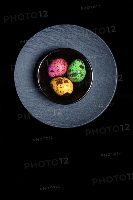 Coloured quail eggs in small bowls