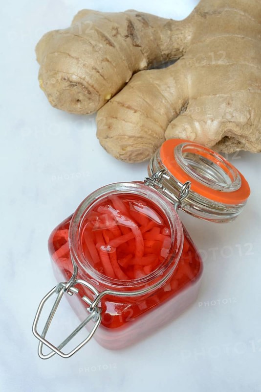 Pickled ginger in glass and ginger root