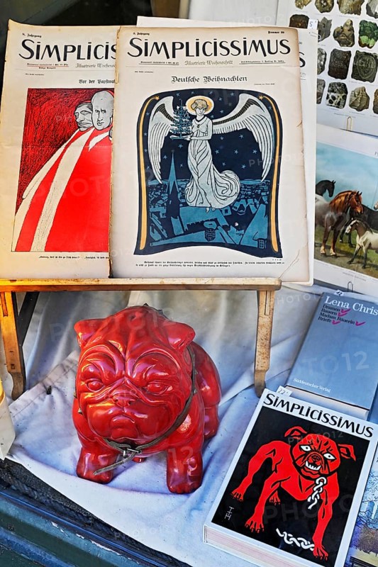Shop window of an antiquarian bookshop with Simplicissimus books and red bulldog