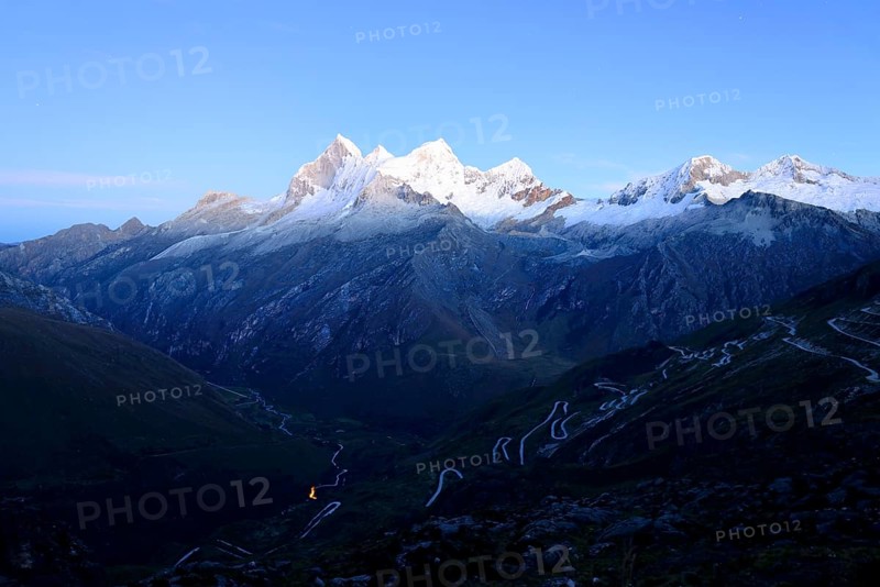 Winding mountain road and massif of Nevado Huandoy at dawn