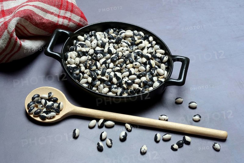 Dried bush beans in pot with cooking spoon