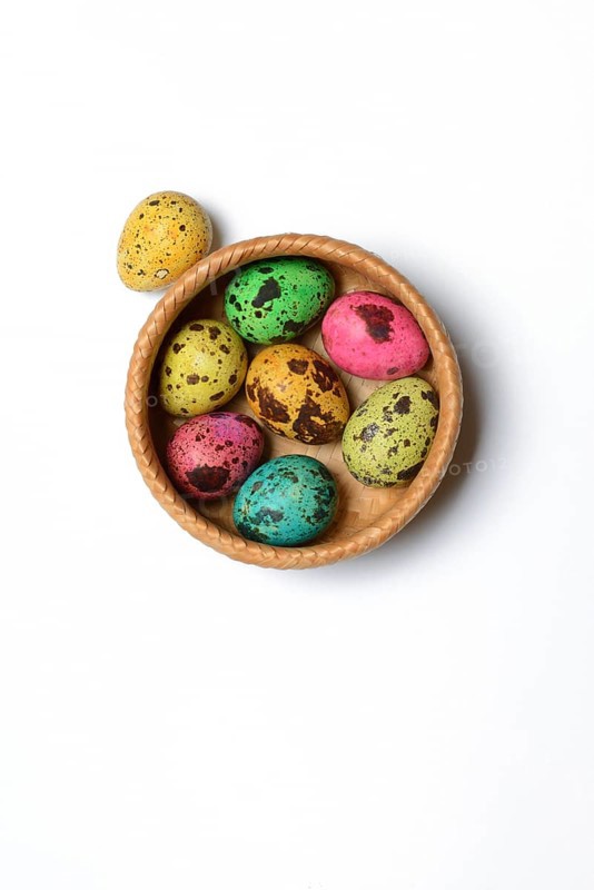 Coloured quail eggs in baskets