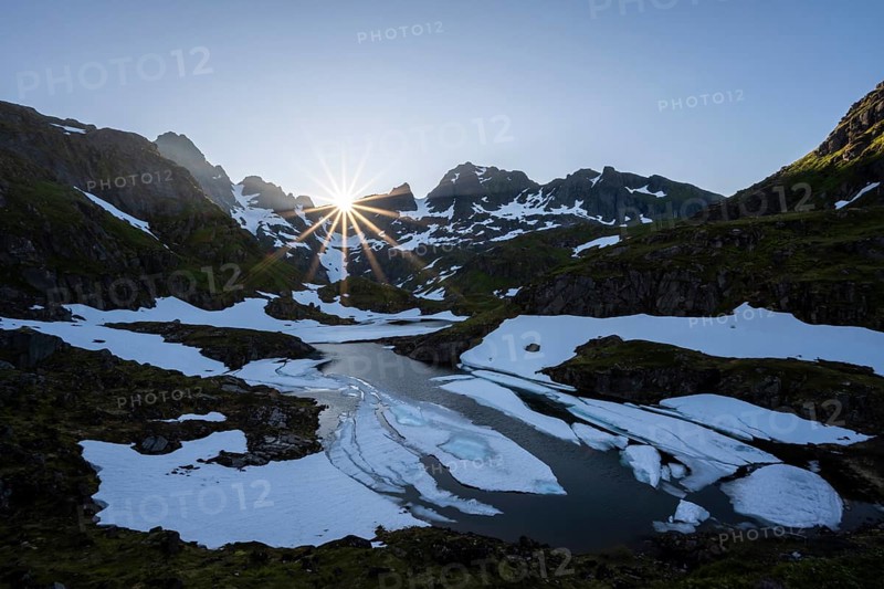 Sun over lake Isvatnet with ice