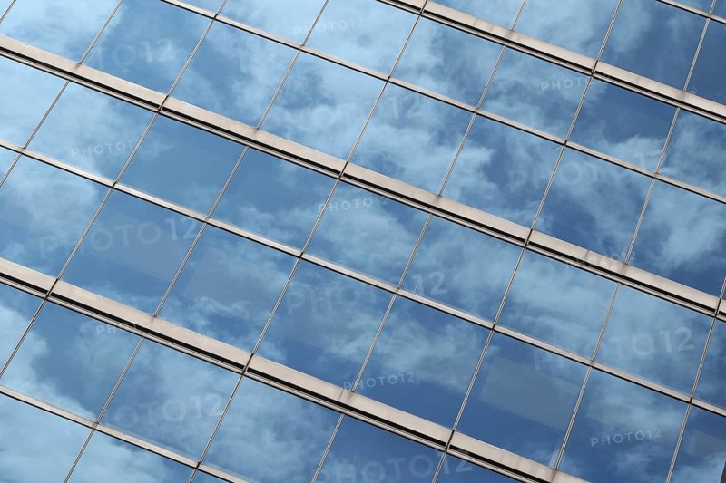 Glas facade with reflection of blue sky and clouds on a business building in Ginza district