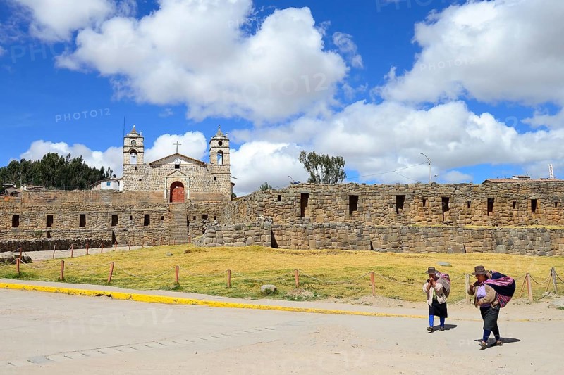 Indigenous woman in front of the Inca sun temple with colonial cathedral on top