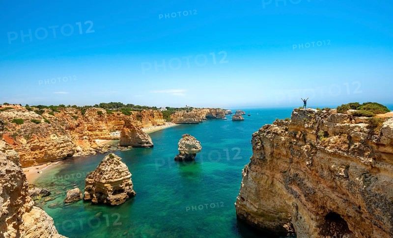 Young man standing on a rock on the cliff