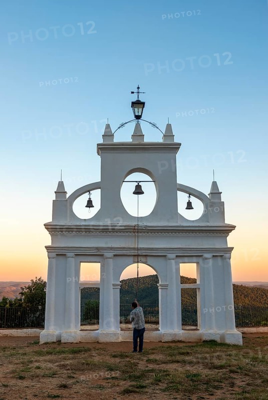 Bell ringer ringing the bells at the bell tower of the chapel Ermita Reina de los Angeles