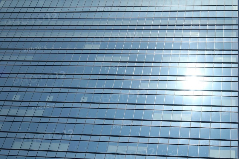 Glas facade of a business building with reflecting sun in Ginza district