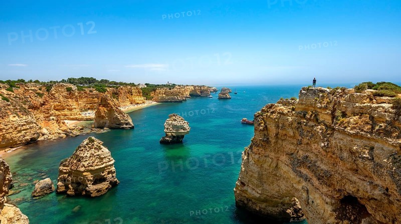 Young man standing on a rock on the cliff