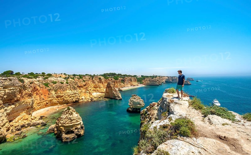 Young man standing on rocks on cliff