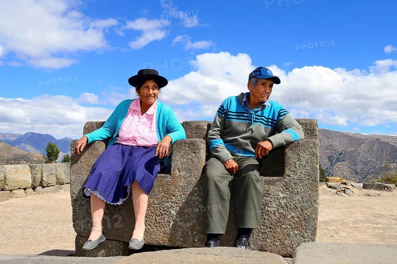 Old indigenous couple sitting on the throne of the Inca on the pyramid