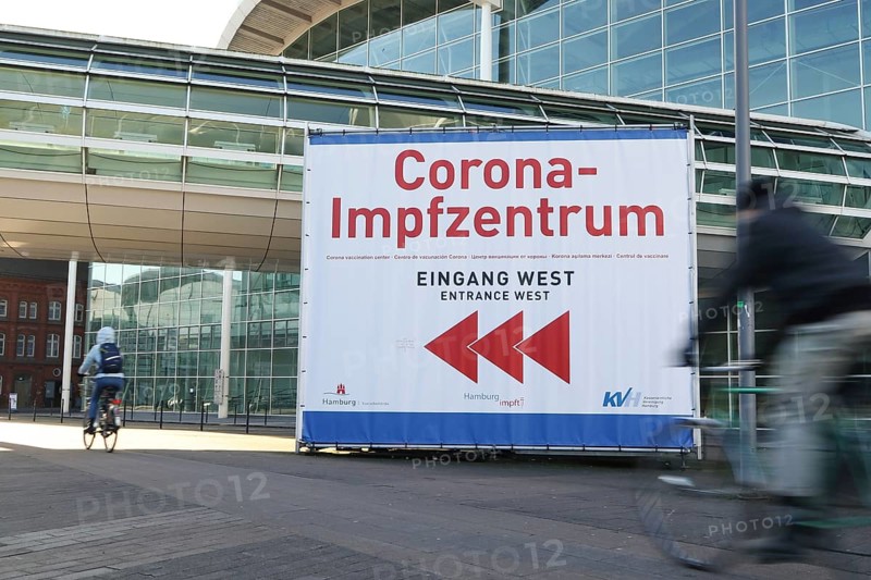 Bicyclist in front of Corona-Impfzentrum Hamburg in the exhibition halls