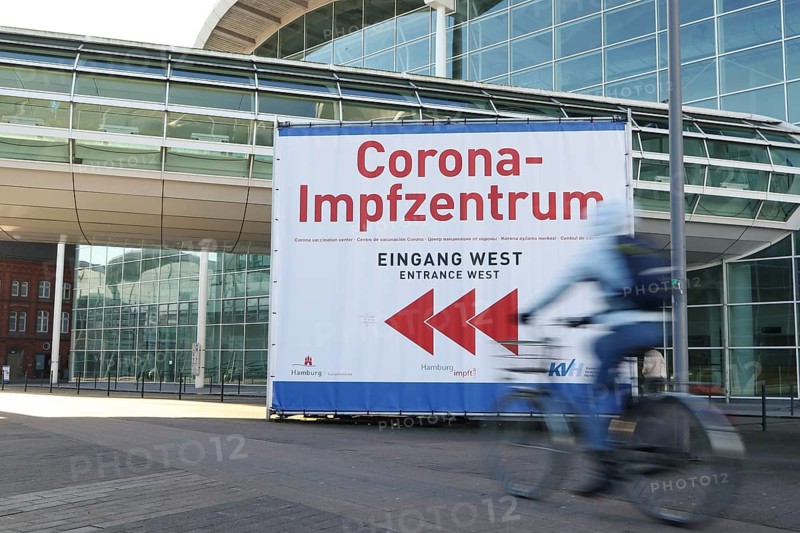 Bicyclist in front of Corona-Impfzentrum Hamburg in the exhibition halls
