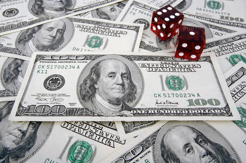 One hundred dollar bills with two red dice