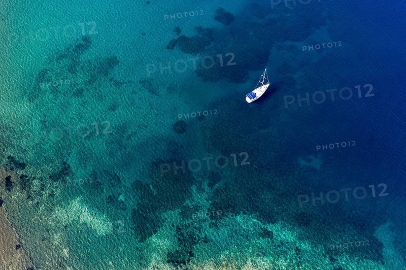 Aerial of a sailing boat in the clear waters of Limnionas beach