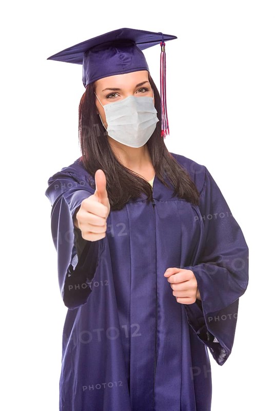 Graduating female wearing medical face mask and cap and gown give a thumbs up isolated on a white background