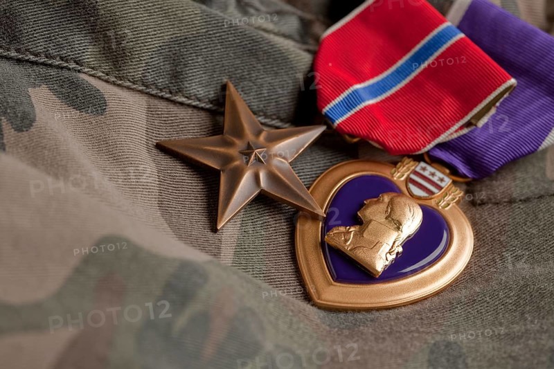 Bronze and purple heart medals on camouflage material