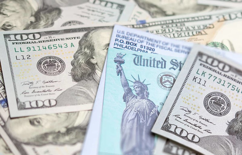 United states IRS check and envelope resting on money