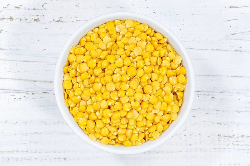 Yellow lentils raw from above wooden board