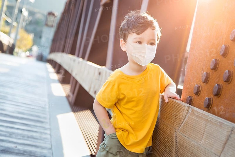 Young Mixed Race Chinese and Caucasian Boy Playing Alone Wearing Medical Face Mask Outside