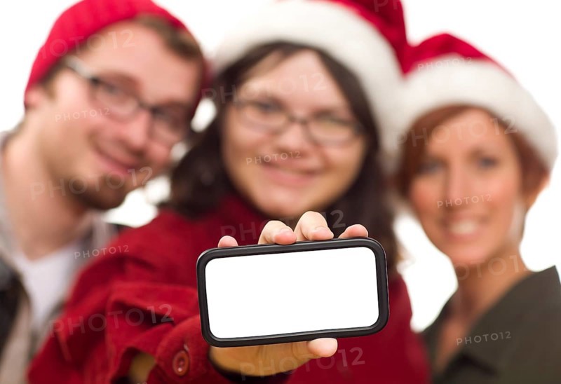 Girl with friends and santa hats holding blank white smart phone