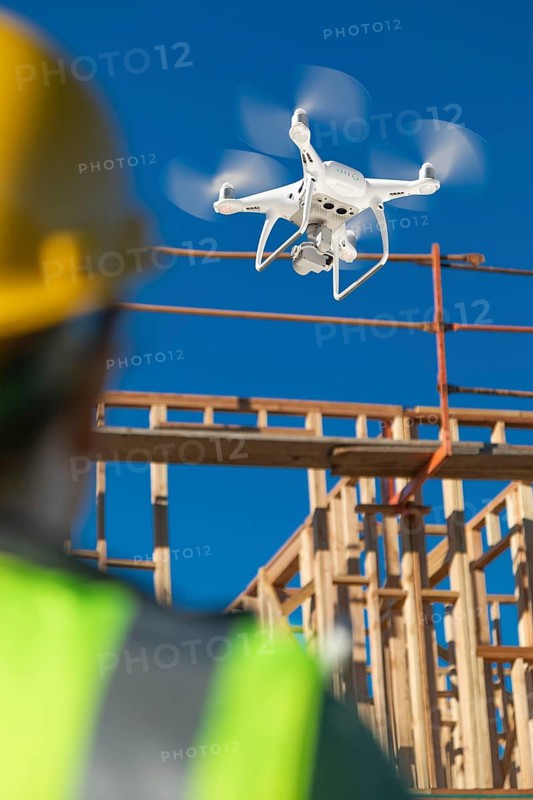 Female pilot flies drone quadcopter inspecting construction site