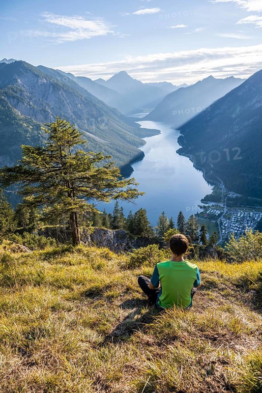 Hiker sitting and looking at Plansee